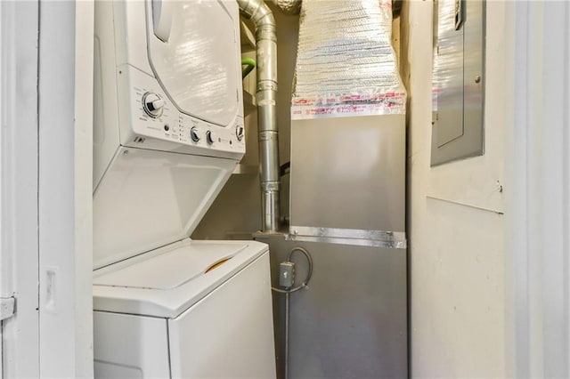 laundry area with electric panel and stacked washer and clothes dryer