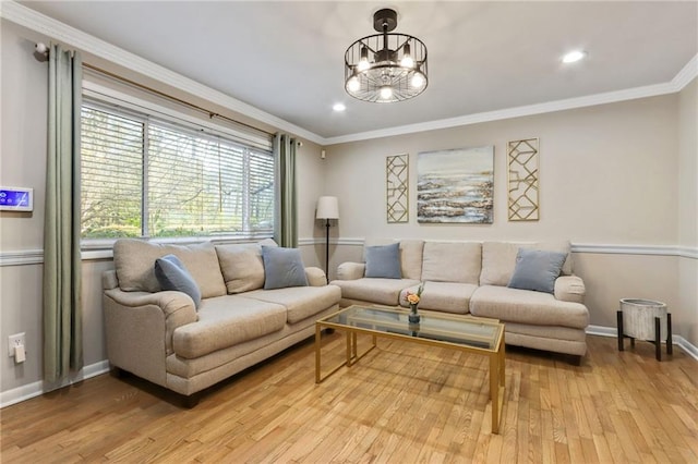 living room featuring light hardwood / wood-style floors, an inviting chandelier, and crown molding