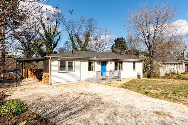 ranch-style home with an attached carport, concrete driveway, and a front yard