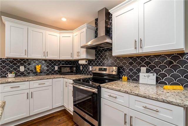 kitchen featuring tasteful backsplash, dark wood finished floors, stainless steel range with electric stovetop, white cabinetry, and wall chimney exhaust hood