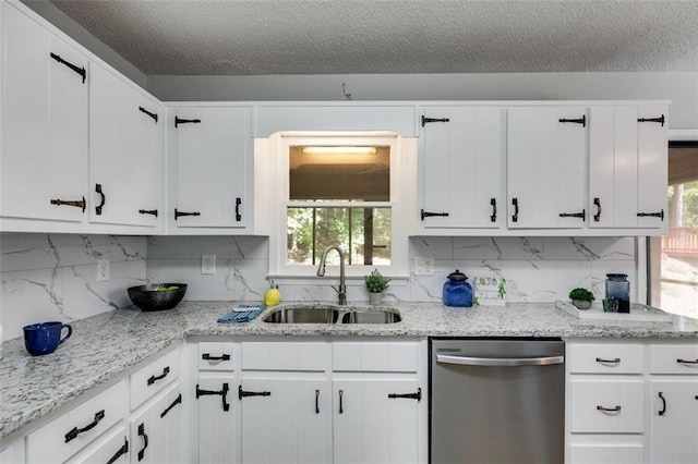 kitchen with white cabinetry, sink, stainless steel dishwasher, and backsplash