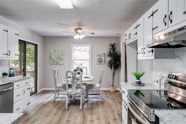 dining room with a textured ceiling, plenty of natural light, light hardwood / wood-style floors, and ceiling fan