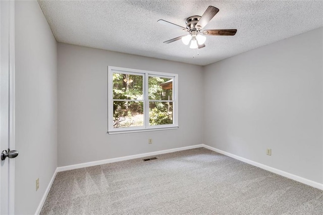 carpeted spare room featuring ceiling fan and a textured ceiling