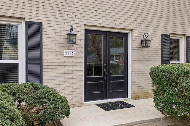 entrance to property featuring french doors and brick siding