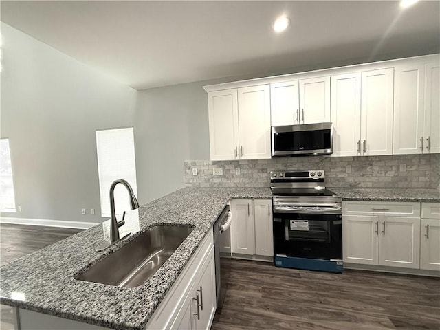 kitchen featuring appliances with stainless steel finishes, sink, white cabinets, light stone counters, and dark wood-type flooring