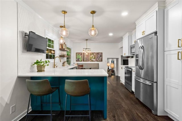 261 Lamplighter Ln SE, Marietta, GA 30067 - kitchen with appliances with stainless steel finishes, white cabinets, light countertops, a kitchen breakfast bar, and ornamental molding
