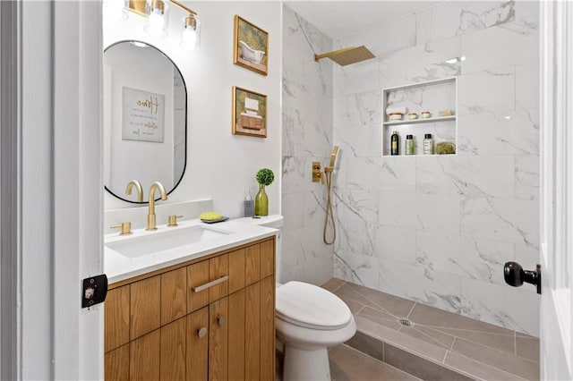 bathroom with vanity, a tile shower, and toilet