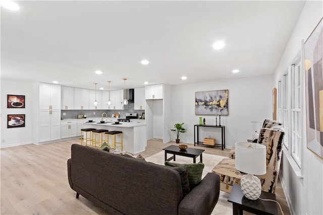 living room featuring sink and light hardwood / wood-style floors