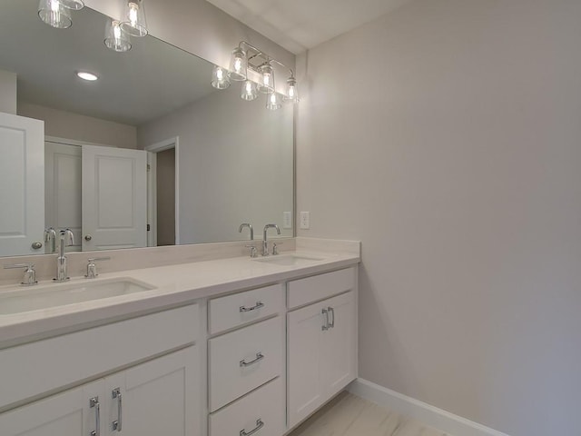 1976 Deco Dr, Kennesaw, GA 30144 - bathroom featuring double vanity, a sink, marble finish floor, and baseboards