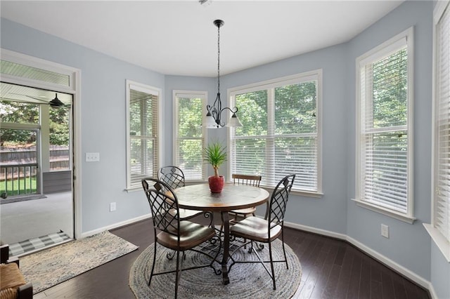 dining space with plenty of natural light, dark hardwood / wood-style flooring, and a notable chandelier