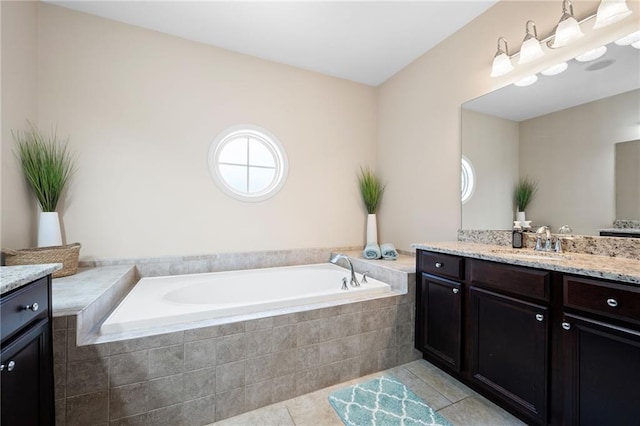 bathroom with tiled tub, tile patterned floors, and vanity