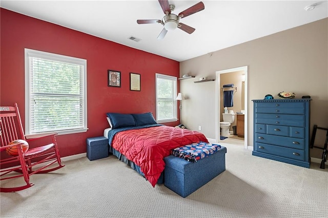 bedroom featuring ceiling fan, multiple windows, carpet, and ensuite bathroom