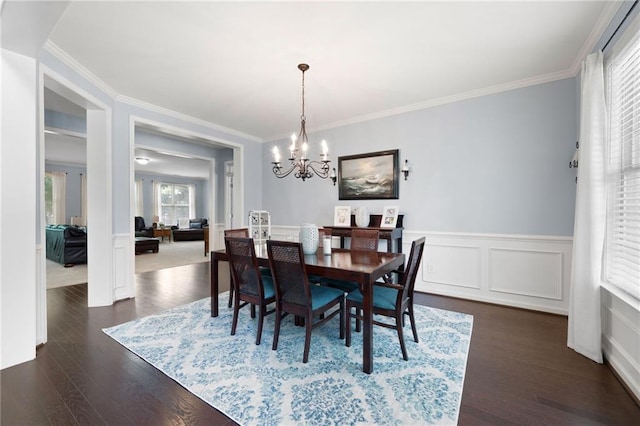 dining area with dark hardwood / wood-style flooring, a notable chandelier, and ornamental molding