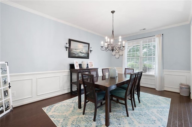 dining room featuring dark hardwood / wood-style floors, crown molding, and a notable chandelier