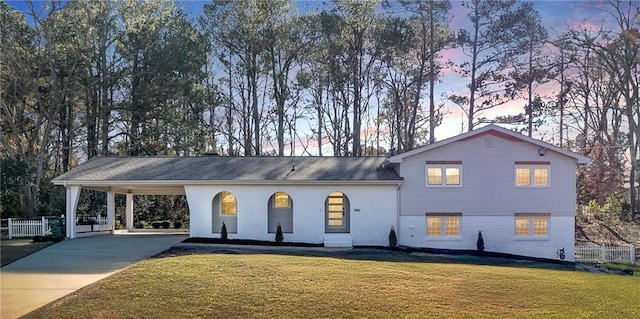 view of front of property with a lawn and a carport