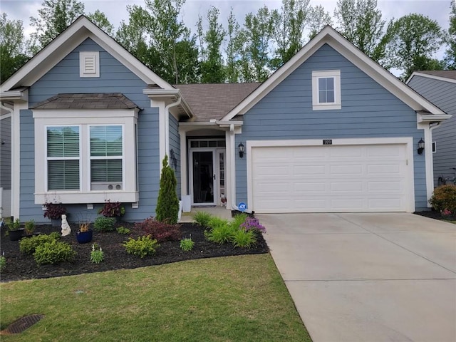view of front facade featuring a garage, a shingled roof, a front yard, and concrete driveway