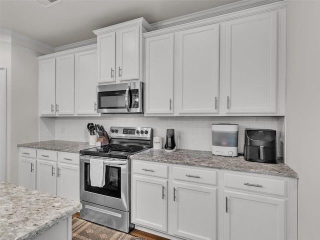 105 Lighthouse Cv SW, Adairsville, GA 30103 - kitchen featuring appliances with stainless steel finishes, white cabinets, tasteful backsplash, and light stone countertops