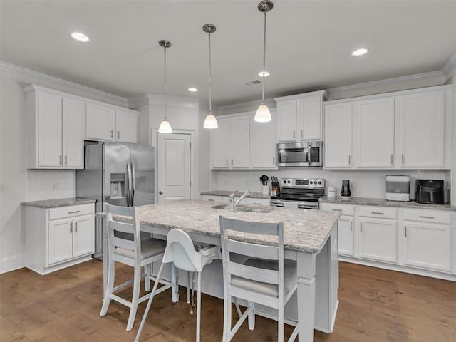 105 Lighthouse Cv SW, Adairsville, GA 30103 - kitchen featuring appliances with stainless steel finishes, ornamental molding, white cabinetry, a center island with sink, and hanging light fixtures