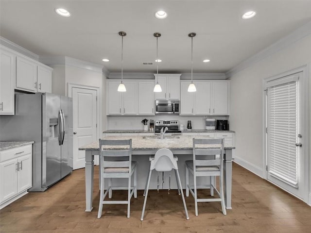 105 Lighthouse Cv SW, Adairsville, GA 30103 - kitchen with appliances with stainless steel finishes, crown molding, white cabinetry, a breakfast bar area, and a center island with sink