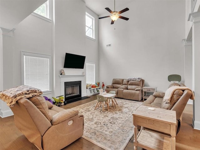 105 Lighthouse Cv SW, Adairsville, GA 30103 - living area featuring a high ceiling, a fireplace with flush hearth, healthy amount of natural light, a ceiling fan, and wood finished floors