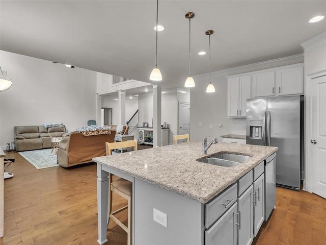 105 Lighthouse Cv SW, Adairsville, GA 30103 - kitchen with stainless steel appliances, pendant lighting, light wood-style flooring, a kitchen island with sink, and open floor plan