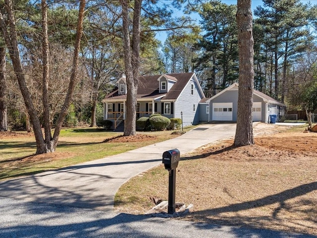 new england style home featuring a garage, an outdoor structure, and a front yard