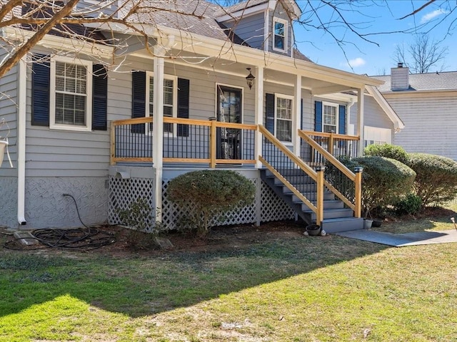 exterior space with roof with shingles, a porch, and a front yard