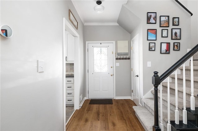 foyer entrance with wood-type flooring, lofted ceiling, and crown molding