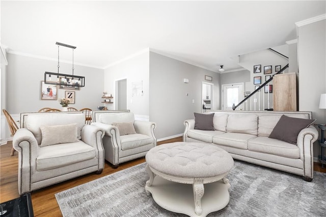 living room featuring wood-type flooring, crown molding, and a chandelier