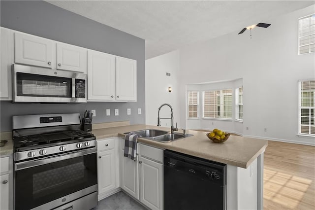 4044 Spring Cove Dr, Duluth, GA 30097 - kitchen featuring stainless steel appliances, a sink, a peninsula, white cabinets, and ceiling fan