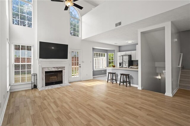 4044 Spring Cove Dr, Duluth, GA 30097 - living room featuring light wood finished floors, a high end fireplace, baseboards, ceiling fan, and stairs