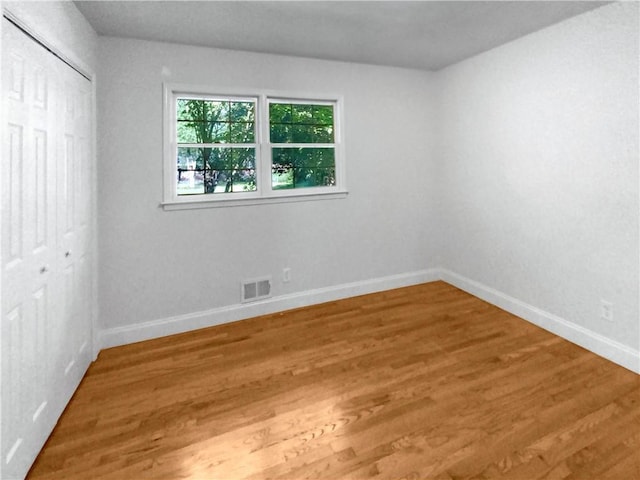 unfurnished bedroom featuring hardwood / wood-style floors and a closet