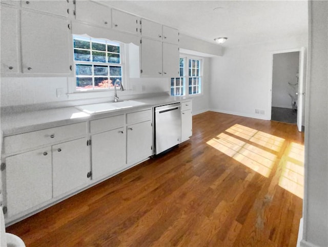 kitchen with decorative backsplash, stainless steel dishwasher, sink, dark hardwood / wood-style floors, and white cabinetry