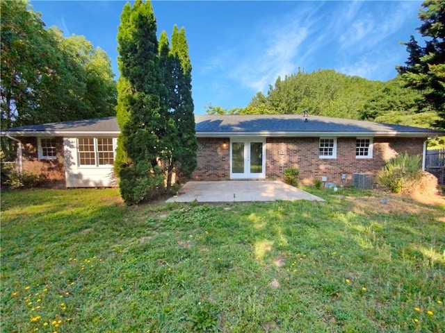 rear view of house with a yard, a patio, central AC, and french doors