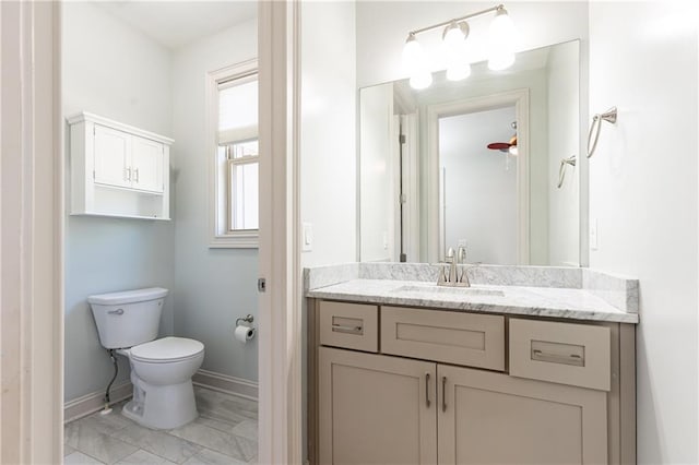 bathroom featuring toilet, ceiling fan, and vanity