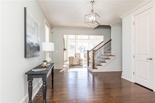 foyer entrance with dark hardwood / wood-style flooring, crown molding, and a notable chandelier