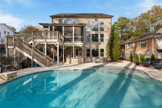 rear view of property with a patio area, a sunroom, and a swimming pool side deck