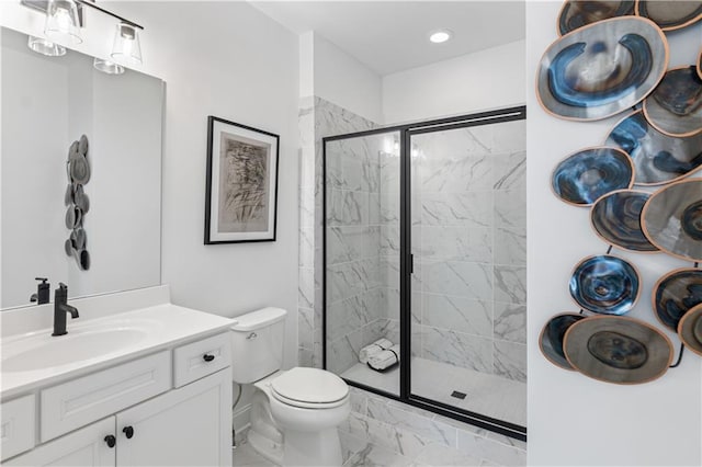 bathroom featuring vanity, toilet, and an enclosed shower