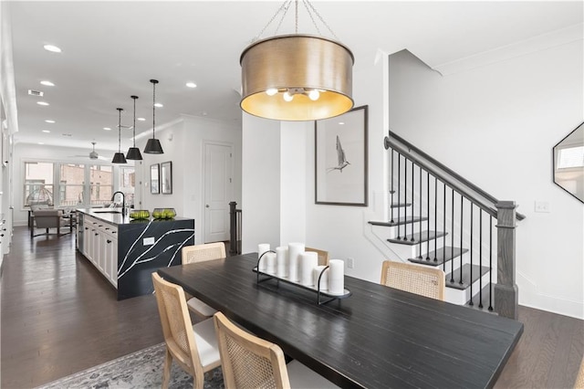 dining room featuring crown molding, sink, and dark hardwood / wood-style flooring