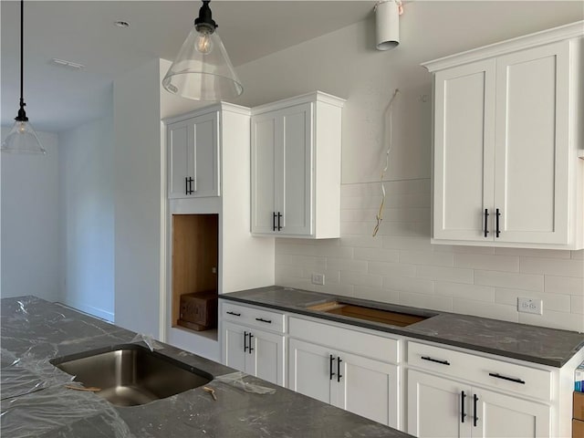 kitchen with white cabinetry, decorative backsplash, and pendant lighting