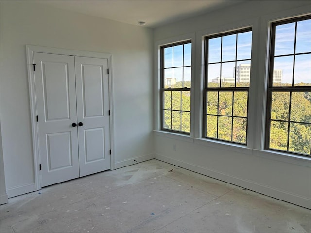 unfurnished bedroom featuring multiple windows and a closet