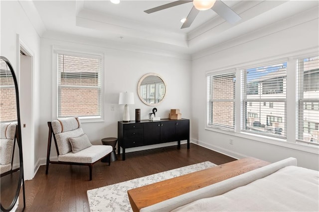 bedroom featuring dark wood-type flooring, a raised ceiling, crown molding, and ceiling fan