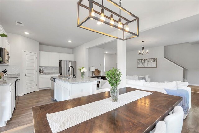 36 Mead Ct, Hoschton, GA 30548 - dining room with wood finished floors, a chandelier, and recessed lighting