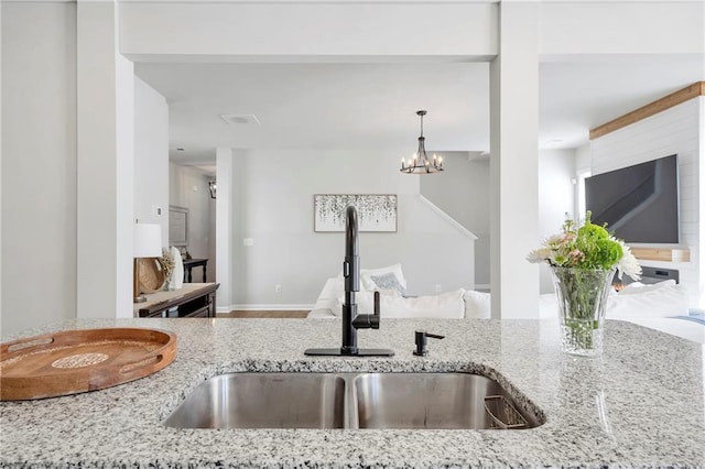 36 Mead Ct, Hoschton, GA 30548 - kitchen featuring light stone counters, a chandelier, and pendant lighting