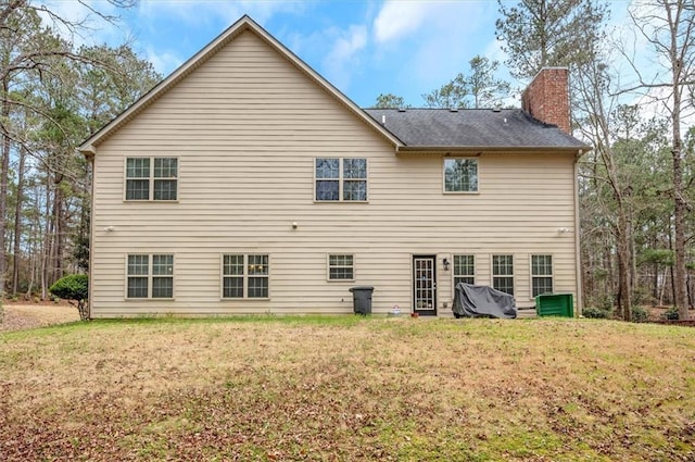 back of property featuring a lawn and a chimney