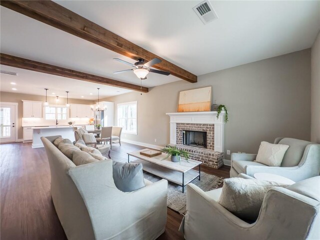 unfurnished living room featuring wood-type flooring, sink, ceiling fan with notable chandelier, and beam ceiling