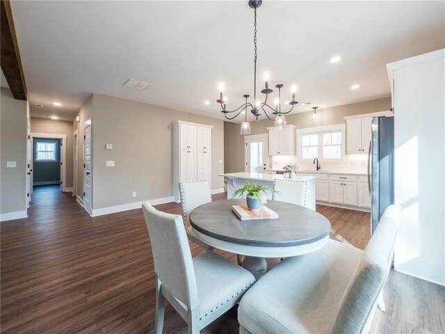 kitchen with decorative light fixtures, tasteful backsplash, white cabinetry, beamed ceiling, and stainless steel appliances