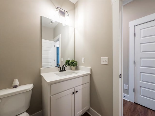 bathroom with vanity, hardwood / wood-style floors, a shower with door, and toilet