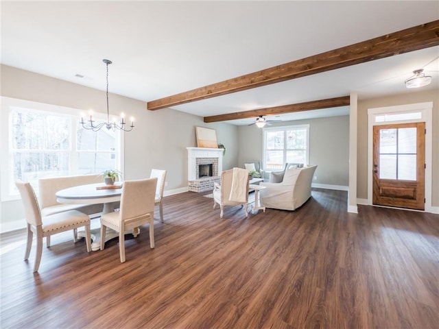 unfurnished living room featuring beam ceiling, a brick fireplace, a healthy amount of sunlight, and dark hardwood / wood-style flooring