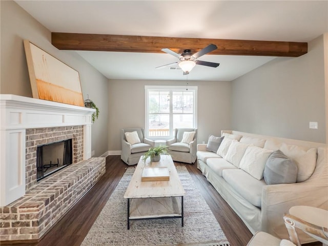 unfurnished living room with beamed ceiling, ceiling fan, a fireplace, and dark hardwood / wood-style flooring